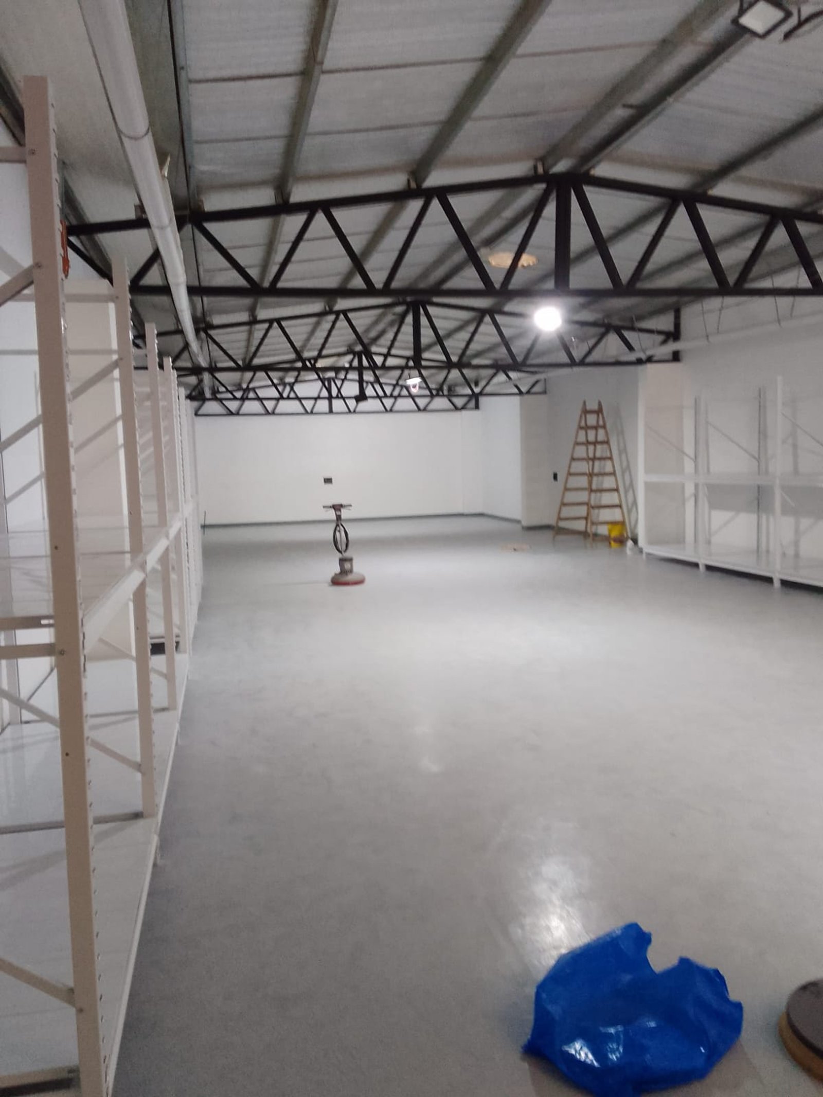 Armazém industrial com prateleiras de metal e piso de cimento — projeto Deposito en Avellaneda 3, por Arquitecto Guido Niccoli, em B1872 Sarandí
